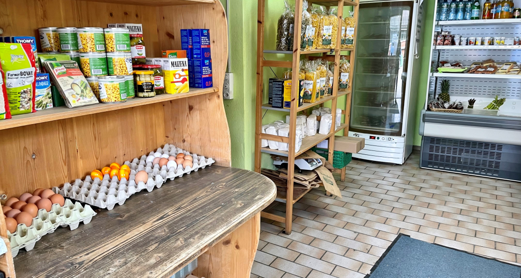 Innenansicht des Hofladens Aeulehof mit Regal voller regionaler Produkte, darunter Eier und Konserven.